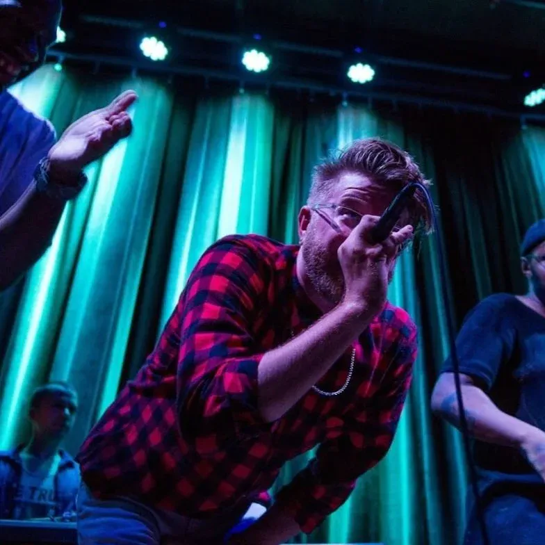 Ryan Kopperud performing live on stage, mic in hand